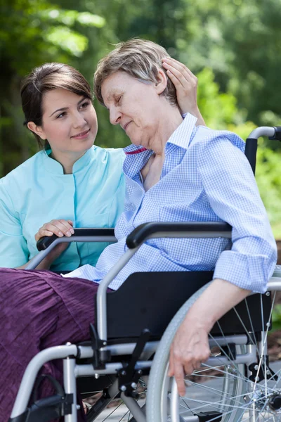 Νοσοκόμα αγκαλιές μια ανάπηρη γυναίκα — Φωτογραφία Αρχείου