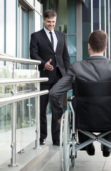 Businessman greeting the disabled man — Stock Photo, Image