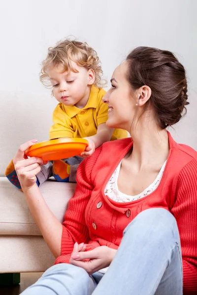 Dítě jíst, zatímco máma pomáhá — Stock fotografie
