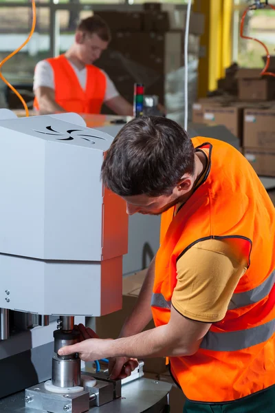 Arbeiter bedient Fabrikmaschine — Stockfoto