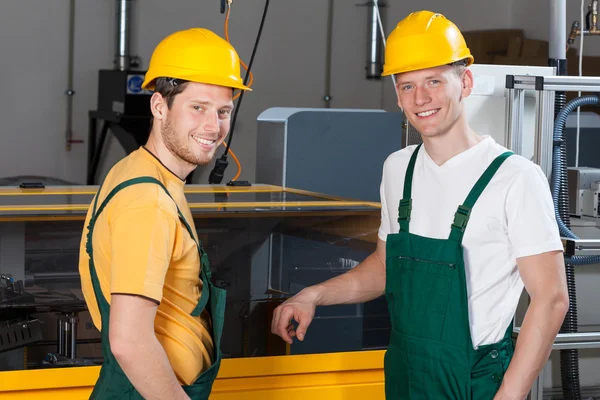 Trabajadores de pie junto a la máquina — Foto de Stock