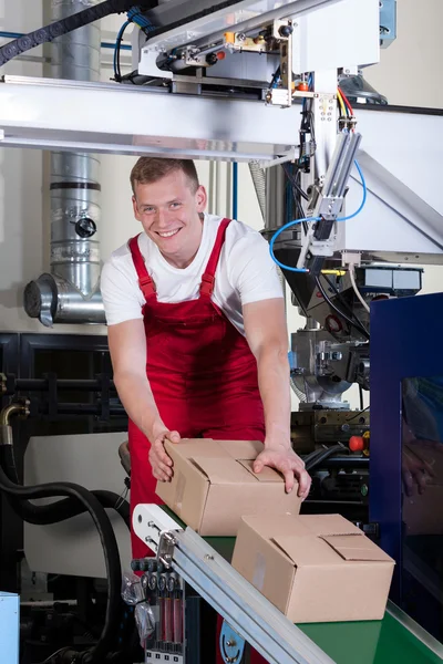 Worker packing boxes on conveyor belt — Stock Photo, Image