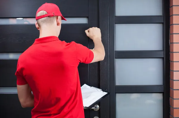 Entrega homem batendo na porta do cliente — Fotografia de Stock