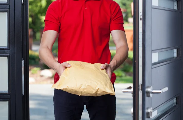 Delivery man giving a package — Stock Photo, Image