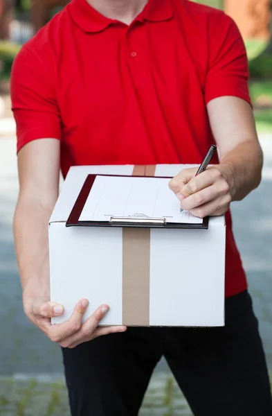 Kurier schreibt ein Transportdokument — Stockfoto