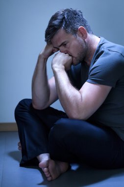 Adam yerde oturuyor.