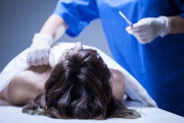 Dead woman lying in mortuary clipart