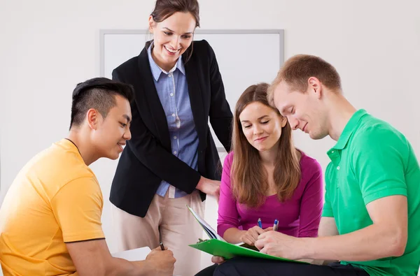 Teacher helping her students with homework Royalty Free Stock Photos