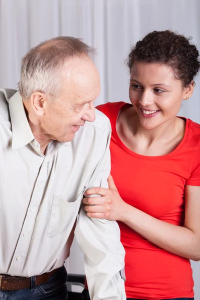 Young volunteer insuring invalid man — Stock Photo, Image