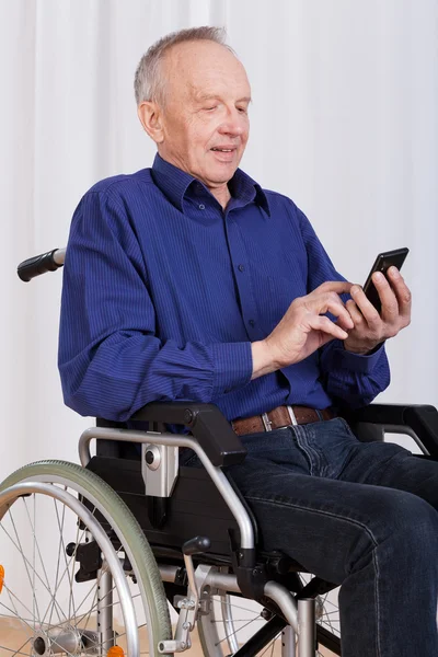 Man on wheelchair sanding text message — Stock Photo, Image