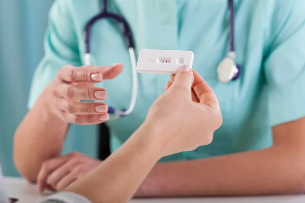 Mulher com teste de gravidez e ginecologista — Fotografia de Stock