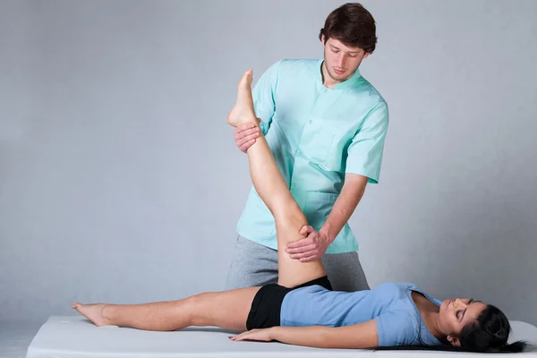 Physiotherapist stretching patient — Stock Photo, Image