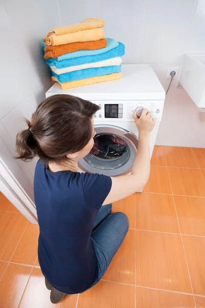 Woman adjusting dial on washing machine — Stock Photo, Image