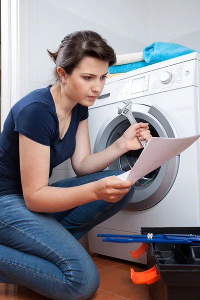 Mujer tratando de reparar la lavadora — Foto de Stock