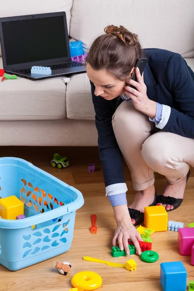 Affärskvinna plocka upp leksaker — Stockfoto