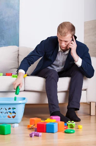 Upptagen pappa städar leksaker — Stockfoto