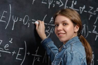 bir kara tahta üzerinde matematik yapıyor güzel öğrenci portresi