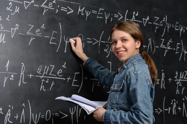 Portrét krásné student dělá matematika na tabuli — Stock fotografie