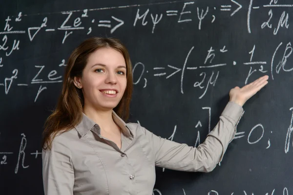Portrét krásné student dělá matematika na tabuli — Stock fotografie