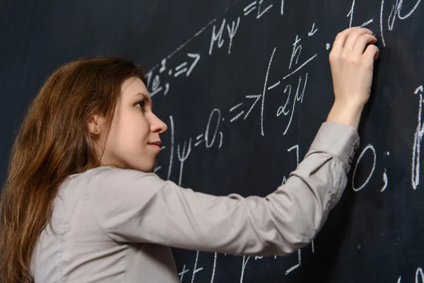 Портрет гарненького студента, що робить математику на дошці Ліцензійні Стокові Фото