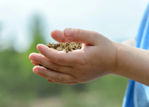 Childs manos con un puñado de tierra — Foto de Stock