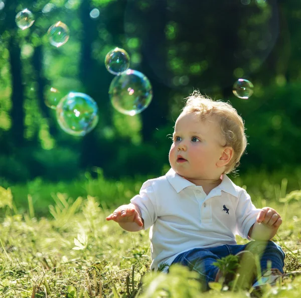 Маленький хлопчик грає з мильними бульбашками Ліцензійні Стокові Зображення