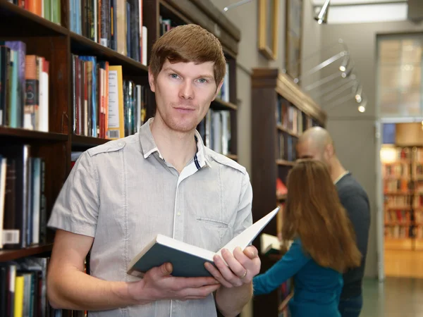 Manlig student i ett bibliotek — Stockfoto