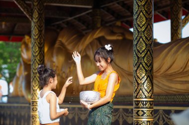 Girl in traditional Thai dress in a Buddhist temple Songkran Festival in Thailand
