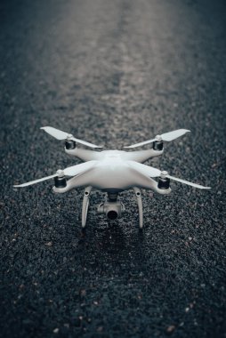 Dmitrov, Rusya - 11 Eylül 2021: Gri ıslak asfalt üzerinde beyaz bir DJI PHANTOM FRO kuadkopteri duruyor.