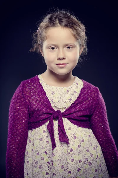 Adorable girl with curly hair posing in a studio — Stock Photo, Image