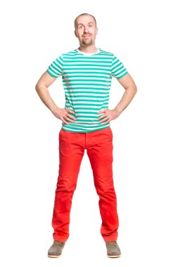 üzerine beyaz izole çizgili beyaz ve turkuaz t-shirt ve turuncu kot pantolon geniş açık gözleri ile neşeli genç gülümseyen adam