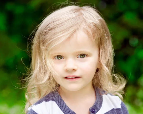 Closeup portrait of an adorable little girl with blond curly hair in summer day — Stock Photo, Image
