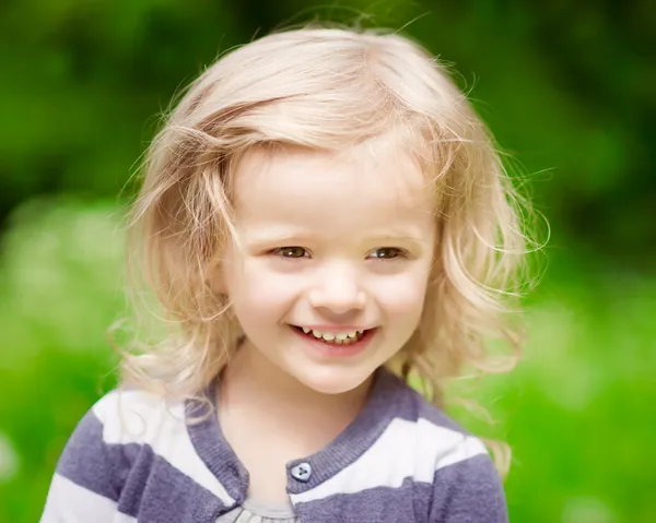 Retrato de cerca de una niña rubia sonriente con el pelo rizado en el día de verano —  Fotos de Stock