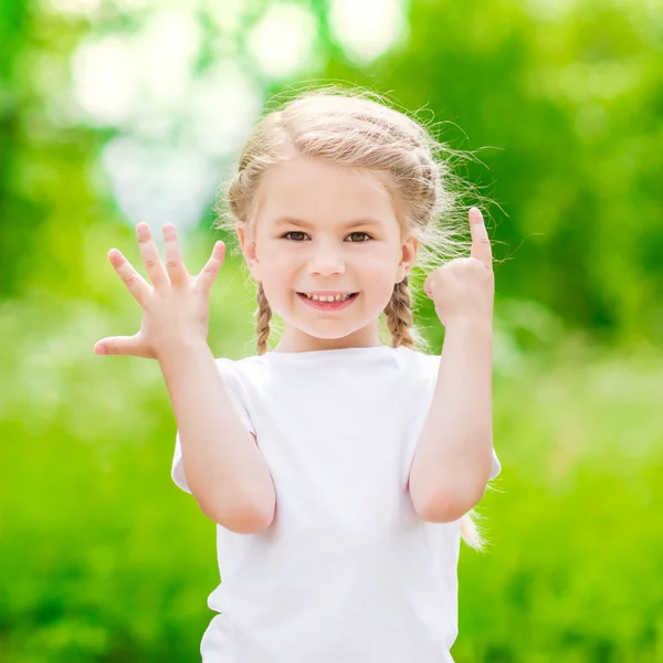 Bella bionda bambina che mostra sei dita (la sua età) e sorridente Foto Stock