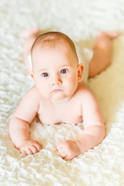 Adorável bebê de seis meses de idade usando fraldas deitadas na cama em casa — Fotografia de Stock