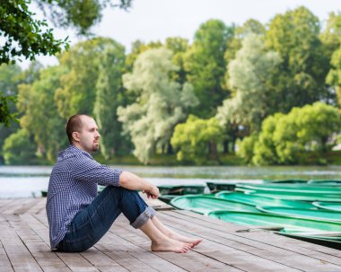 meditasyon ve rahatlatıcı yaz gün, ahşap iskele üzerinde oturan adam yakışıklı genç sakallı