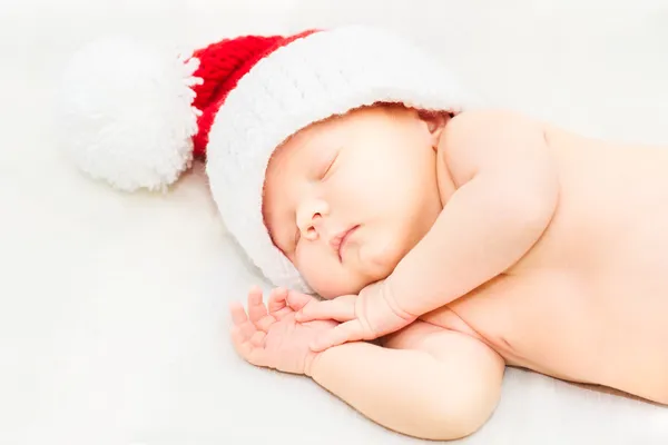 Adorabile neonato addormentato che indossa il cappello di Babbo Natale, Natale, Capodanno Foto Stock Royalty Free