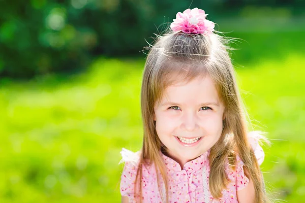 Beautiful smiling little girl with long blond hair, closeup outdoor portrait in summer park — Stock Photo, Image