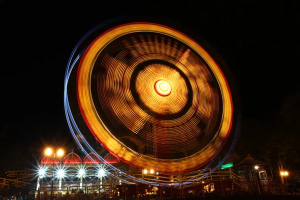 Roda gigante em movimento iluminada à noite — Fotografia de Stock