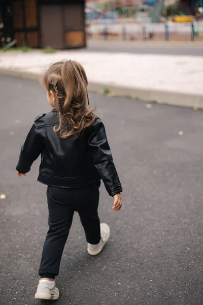 가을에 야외를 걷고 있는 검은 색옷을 입은 행복 한 꼬마 — 스톡 사진