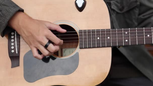 Primer plano del adolescente tocando la guitarra. Dedo masculino en cuerdas. El chico toca música. Humor de otoño al aire libre — Vídeos de Stock