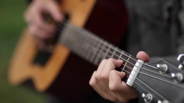 Detailní záběr teenagera hrajícího na kytaru. Mužský prst na strunách tvoří akord. Podzimní nálada — Stock video