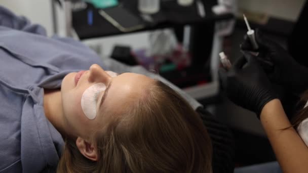 Kosmetikerin macht Wimpernkaschierung Verfahren für junge Modell. Moderne Verfahren zur Wimpernpflege, bei denen Wimpern laminiert und verlängert werden. Professionelles Schönheitsstudio — Stockvideo