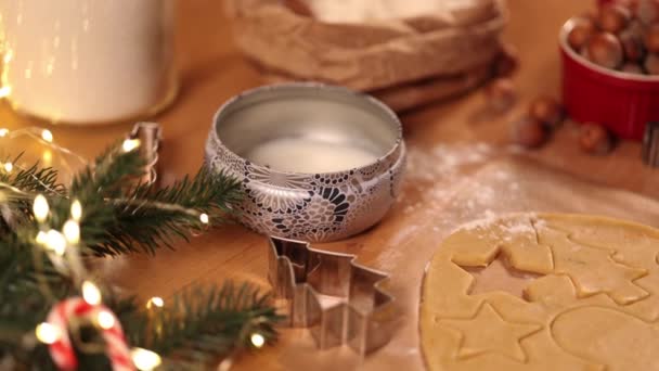 Uma mulher acende uma vela no Natal. Preparação para assar pão de gengibre. Humor de Natal — Vídeo de Stock