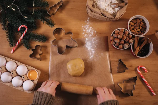 Woman using rolling pin for making gingerbread. Close-up of rolling raw dough for gingerbread. Christmas mood. Preparing for hollidays. Top view — Stock Photo, Image