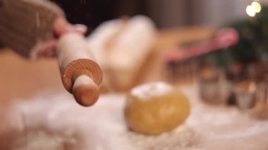 Kadın zencefilli ekmek yapmak için merdaneye un serpiyor. Noel havası. Yan görüş. Yavaş çekim