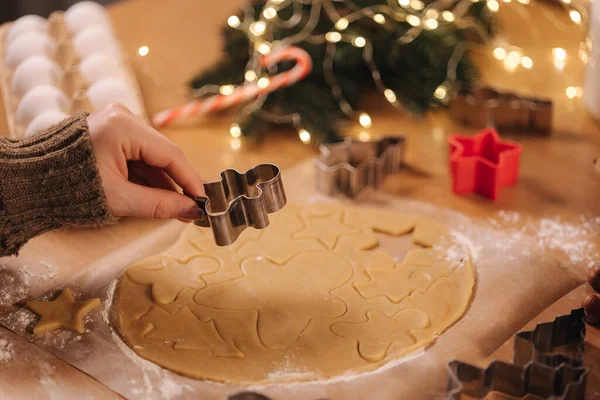 Woman making gingerbread at home. Female cutting cookies of gingerbread dough, view from above. Top view of woman using making gingerbrean star-shaped — Stock Photo, Image