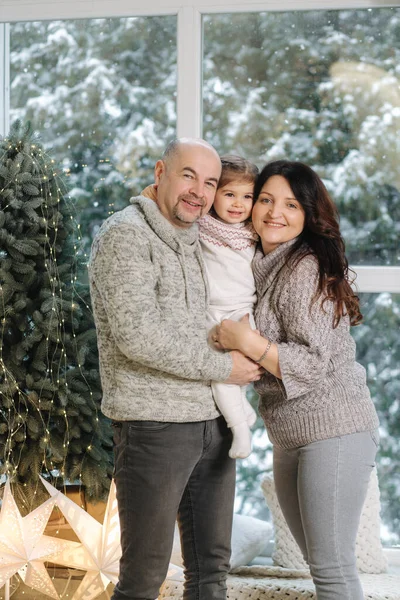 부모는 집에 있는 전나무 근처에서 손녀를 껴안는다. 행복 한 사람들의 크리스마스 기분 — 스톡 사진