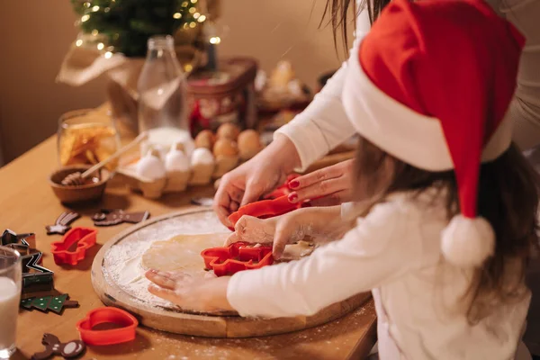 Evde zencefilli ekmek yapıyorum. Annesiyle küçük bir kız zencefilli kurabiye hamuru kesiyor. Noel ve Yeni Yıl gelenekleri. Noel pastanesi. İyi tatiller.