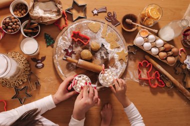 Kış içkisinin en üst görüntüsü, beyaz kazaklı kadın ellerinde lokum olan beyaz kupa. Ev yapımı fırın, geleneksel festival tatlısı pişirmek. Tahta masada zencefilli ekmek hamuru. Yeni yıl kutlaması
